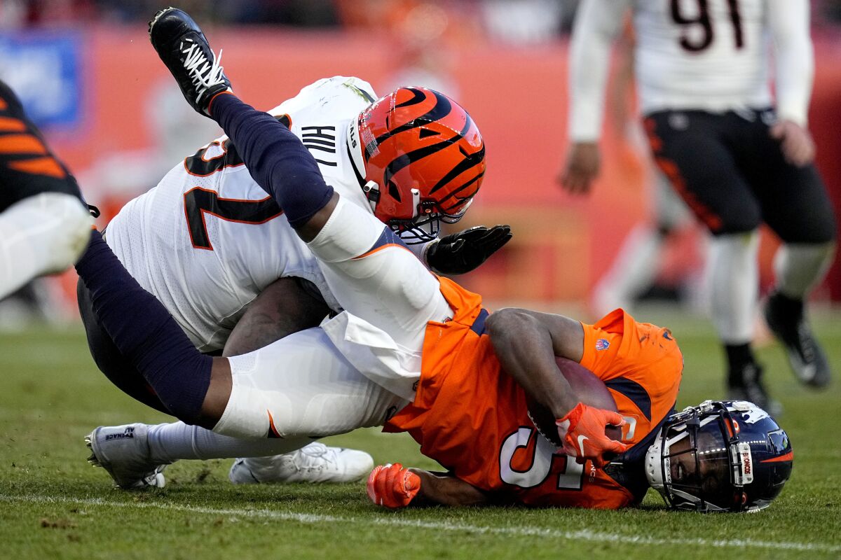 Denver Broncos quarterback Teddy Bridgewater (5) is hit by Cincinnati Bengals defensive end B.J. Hill during the second half of an NFL football game, Sunday, Dec. 19, 2021, in Denver. Bridgwater left the game after being injured on the play. (AP Photo/Jack Dempsey)