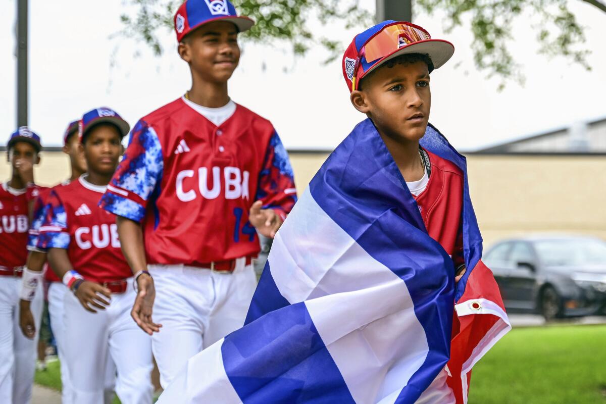 Esta foto distribuida por Caleb Craig muestra a Alfredo Despaigne liderando la llegada del equipo de Cuba 