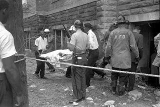 FILE - Firefighters and ambulance attendants remove a covered body from the 16th Street Baptist Church in Birmingham, Ala., Sept. 15, 1963, after a deadly explosion detonated by members of the Ku Klux Klan during services. Alabama on Friday, Sept. 15, 2023, will mark the 60th anniversary of the bombing that killed four girls. Lisa McNair, the sister of one of the victims, said as the anniversary is remembered, she hoped people will think about what they can do to combat hate. (AP Photo, File)