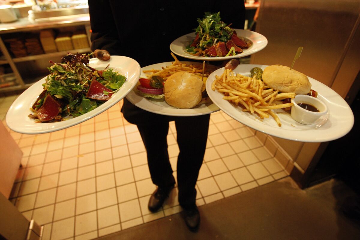 Waiter Branden Adams prepares to deliver lunch to patrons at the Yard House restaurant.
