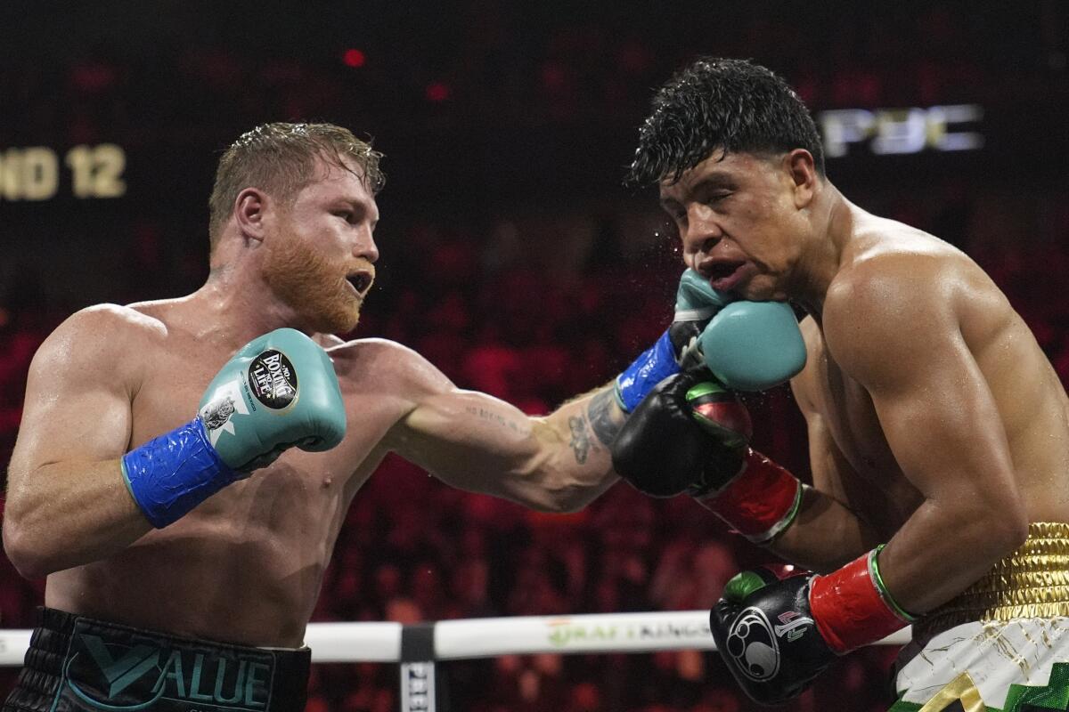 Canelo lvarez punches Jaime Munguia during their super middleweight fight in Las Vegas on Saturday night.