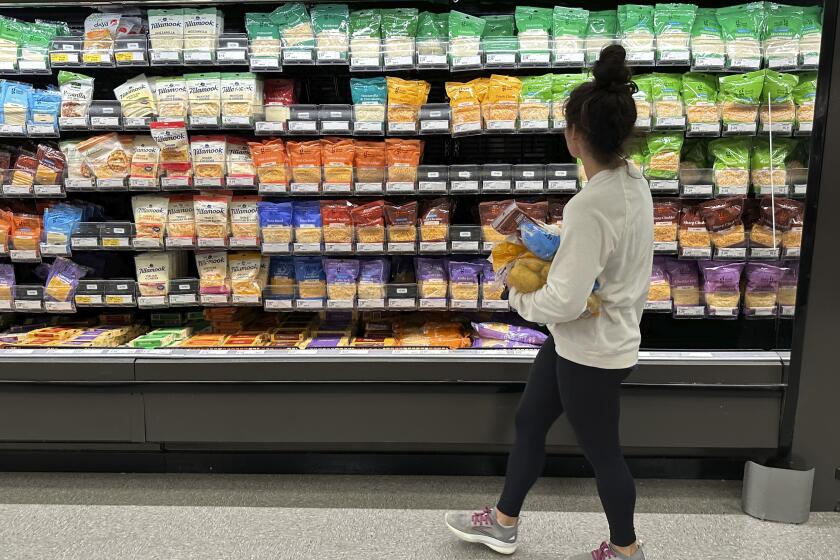 File - A shopper peruses cheese offerings at a Target store on Oct. 4, 2023, in Sheridan, Colo. Inflation is easing slightly, but grocery prices are still high. (AP Photo/David Zalubowski, File)