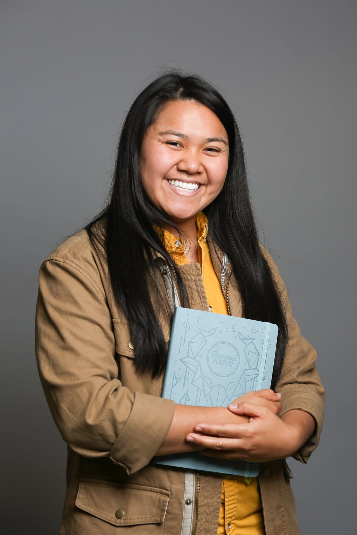 Angelia Trinidad, San Diego native and founder of Passion Planner, holds one of her planners