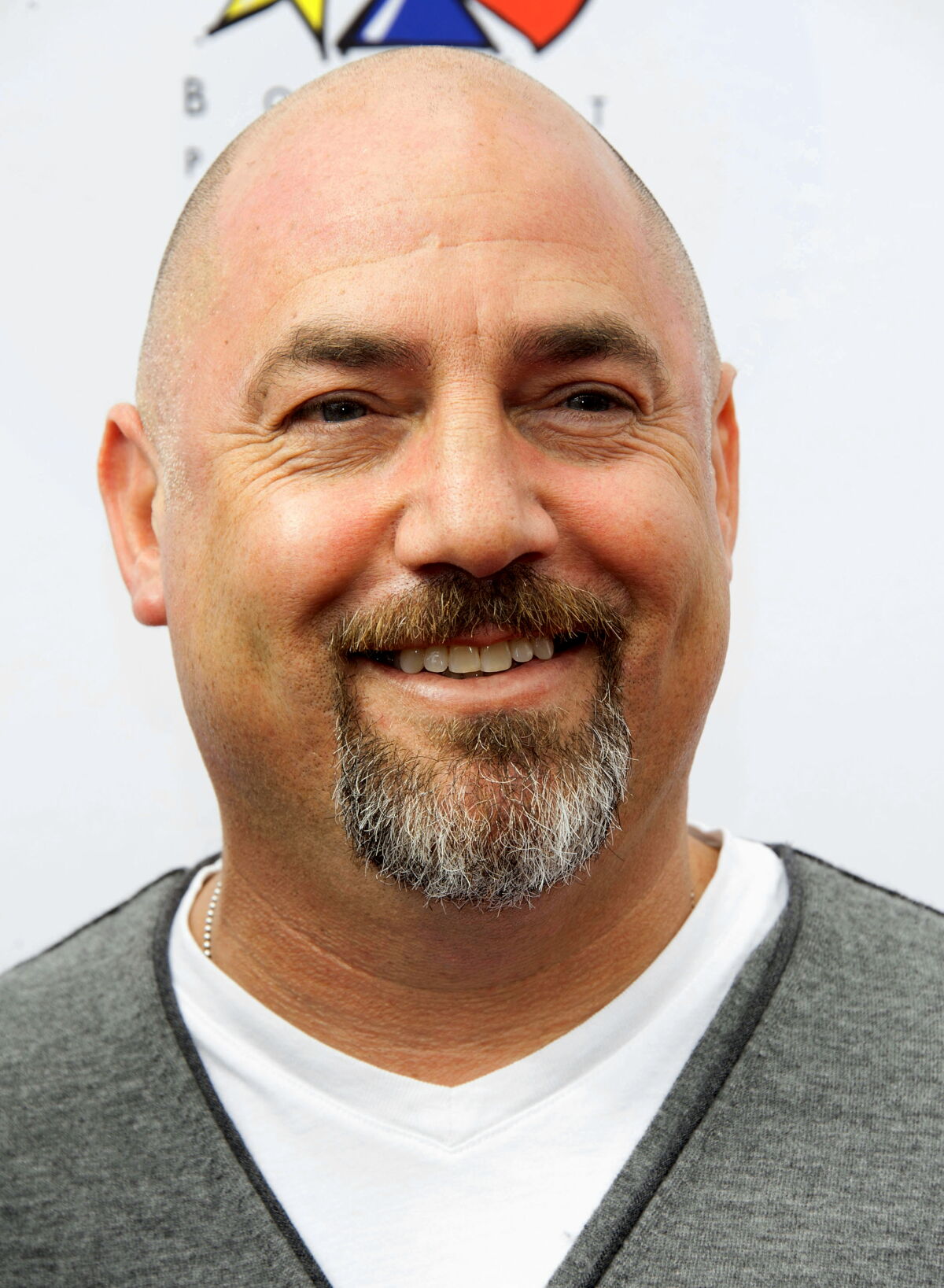 headshot of a man in a gray sweater