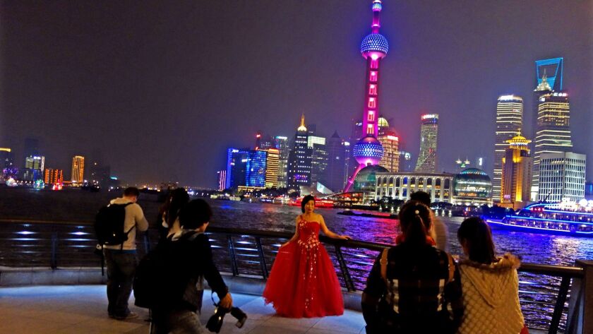A bride poses along the waterfront in Shanghai.