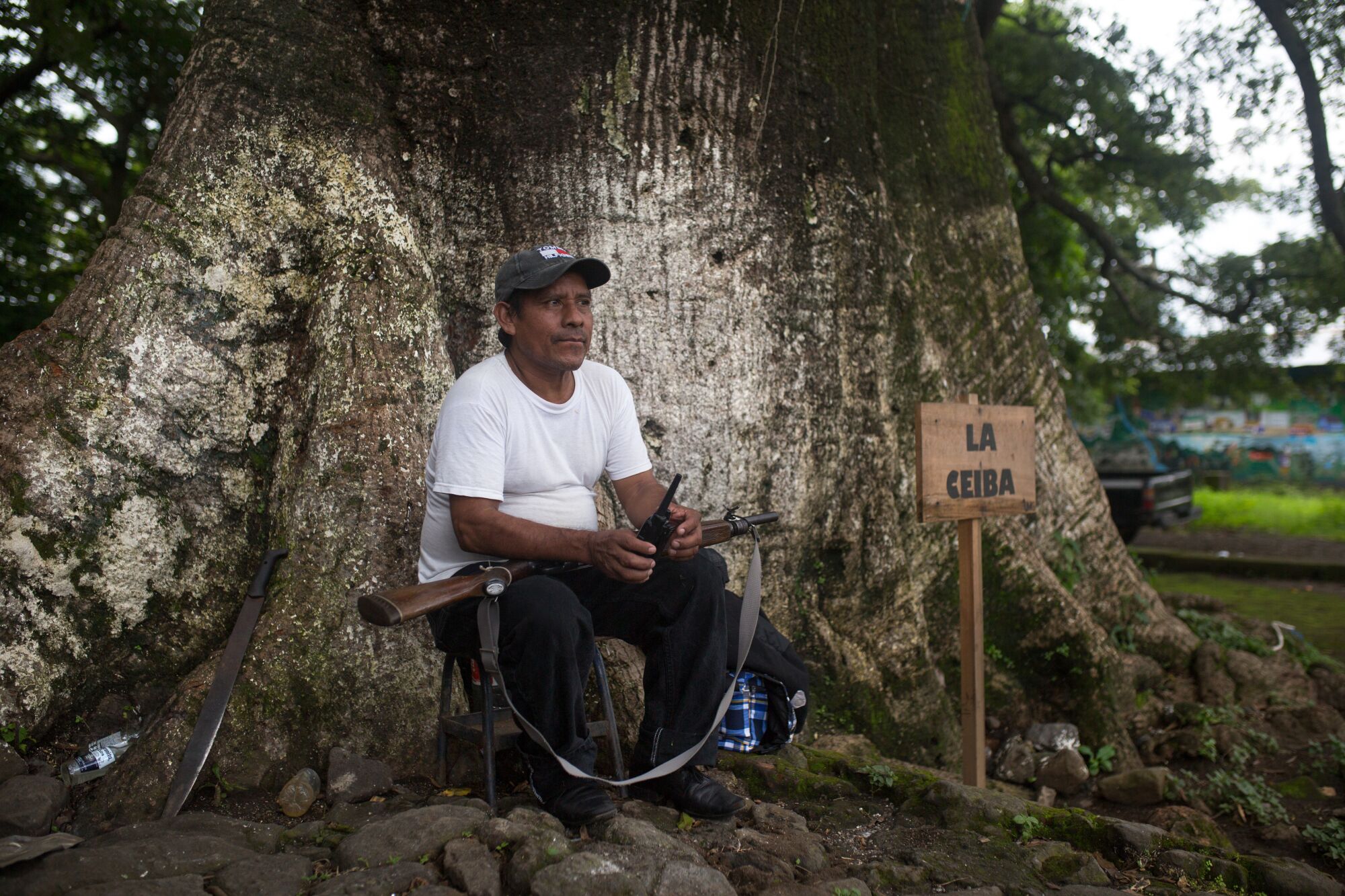 War survivor Bernanrdo Cruz stands guard under the Ceiba tree that serves as the community center in La Trinidad.