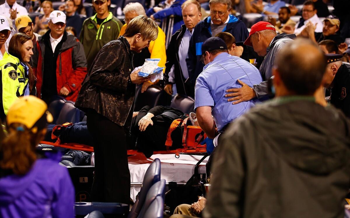 A woman is taken out by medical personnel on a stretcher after being struck by a foul ball in the back of the head in the second inning during a Pirates/Cubs game at PNC Park.