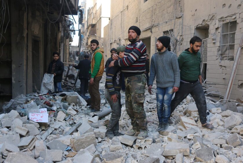 A man comforts a boy after a reported airstrike on a rebel-held neighborhood in Aleppo, Syria, on Feb. 4.