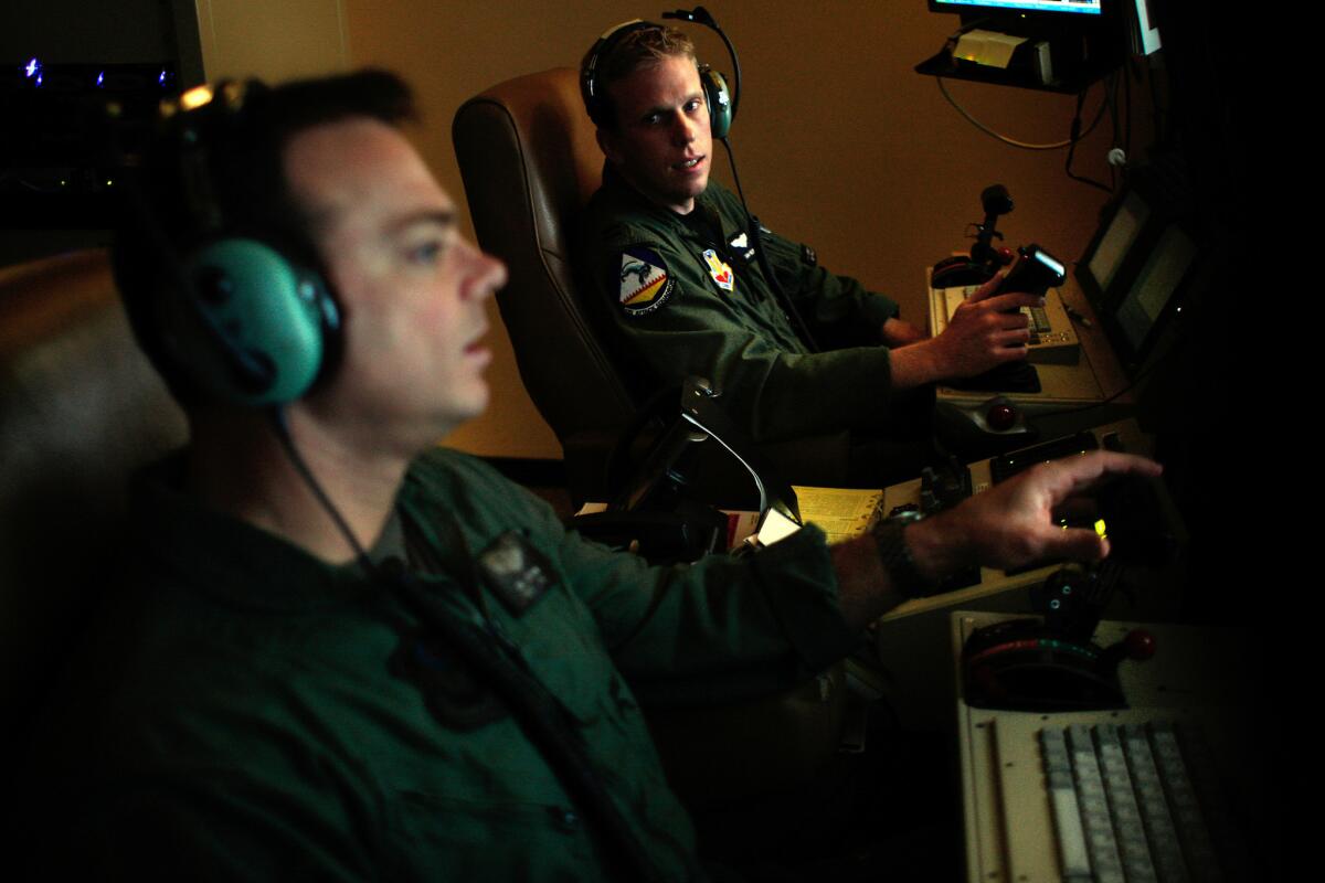Sgt. James Jochum, left, and Capt. Sam Nelson at work at Creech Air Force Base in Nevada. “Every single day this base is at war,” said Col. James R. Cluff, the commander of Creech. “These kids are not playing video games out of their mothers' basements.”
