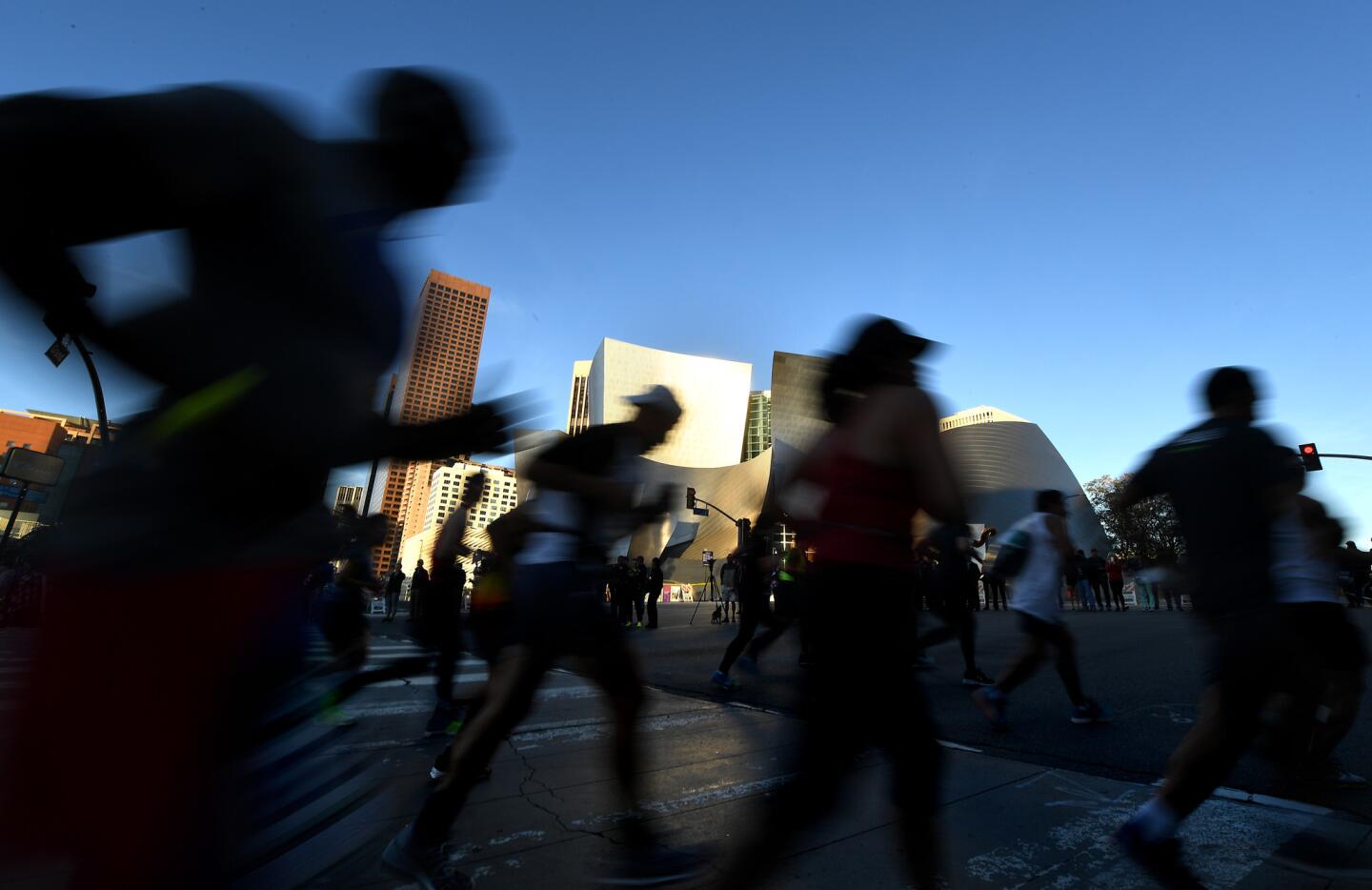 Competitors run past Disney Hall during the L.A. Marathon Sunday morning.