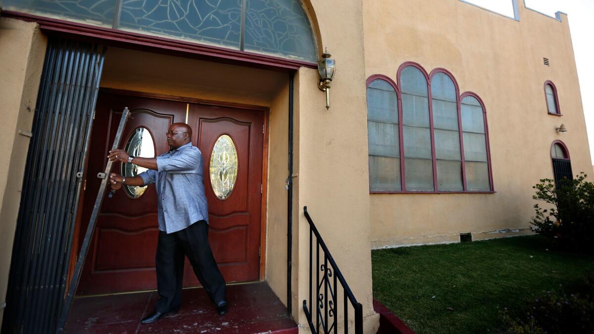 Pastor Kenneth Little unlocks Ebenezer Baptist Church in South Los Angeles. The L.A. city attorney has sued the church in order to address gang violence at a church-owned property across the street.