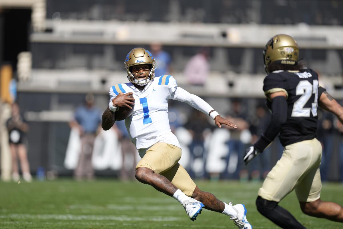 UCLA quarterback Dorian Thompson-Robinson is pursued by Colorado safety Isaiah Lewis 