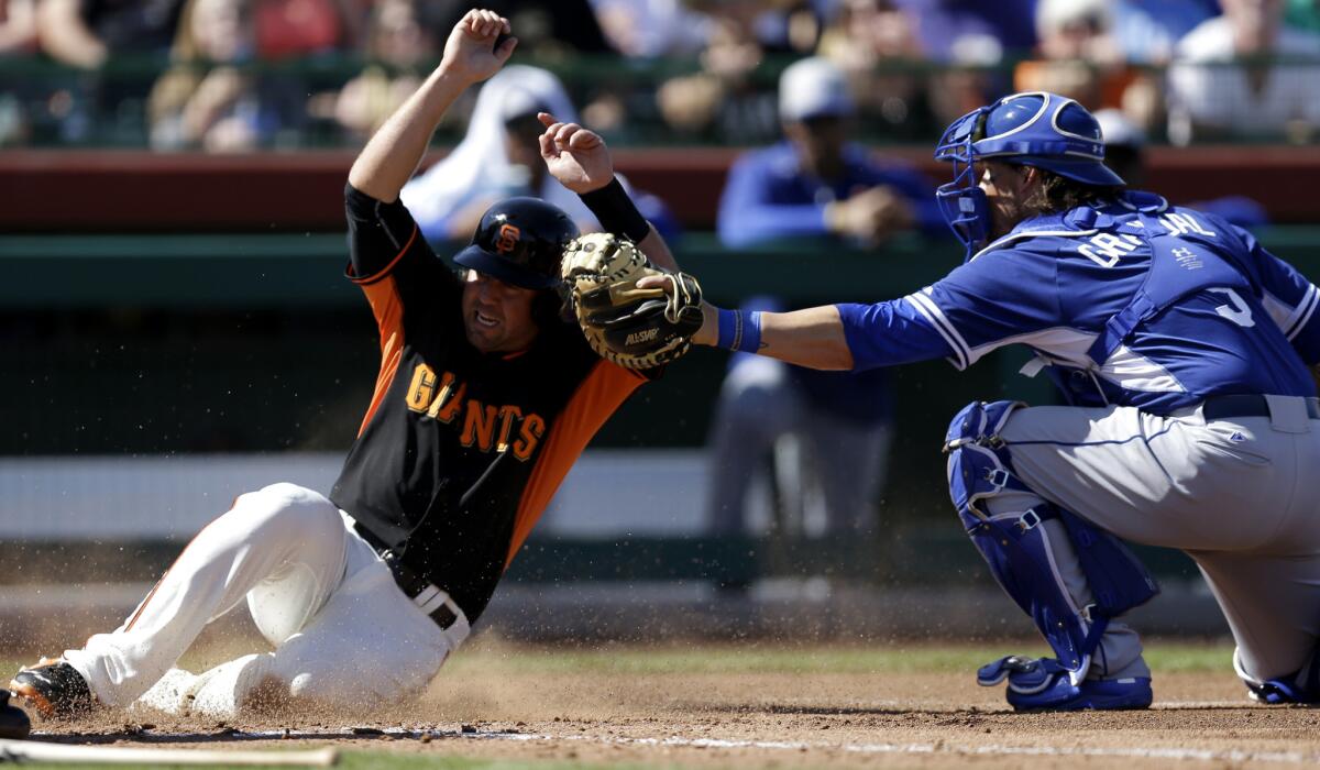 Dodgers catcher Yasmani Grandal, right, tags out the Giants' Brandon Hicks during a spring training game March 9. The two teams will meet 12 times before the All-Star break.