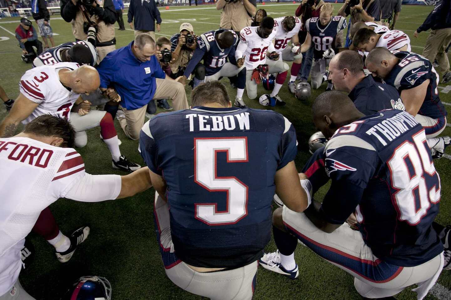 Tim Tebow prays with his teammates