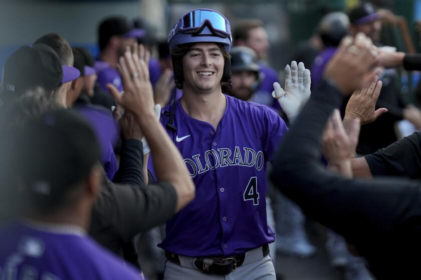 Michael Toglia de los Rockies de Colorado celebra en el dugout su jonrón en la segunda entrada del juego ante los Angelinos de Los Ángeles el jueves 1 de agosto del 2024. (AP Foto/Eric Thayer)