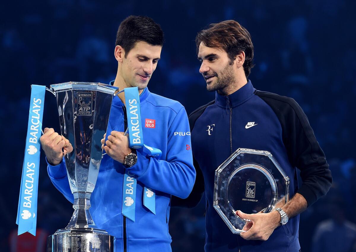 Novak Djokovic, left, and Roger Federer accept their trophies after the ATP finals on Sunday.