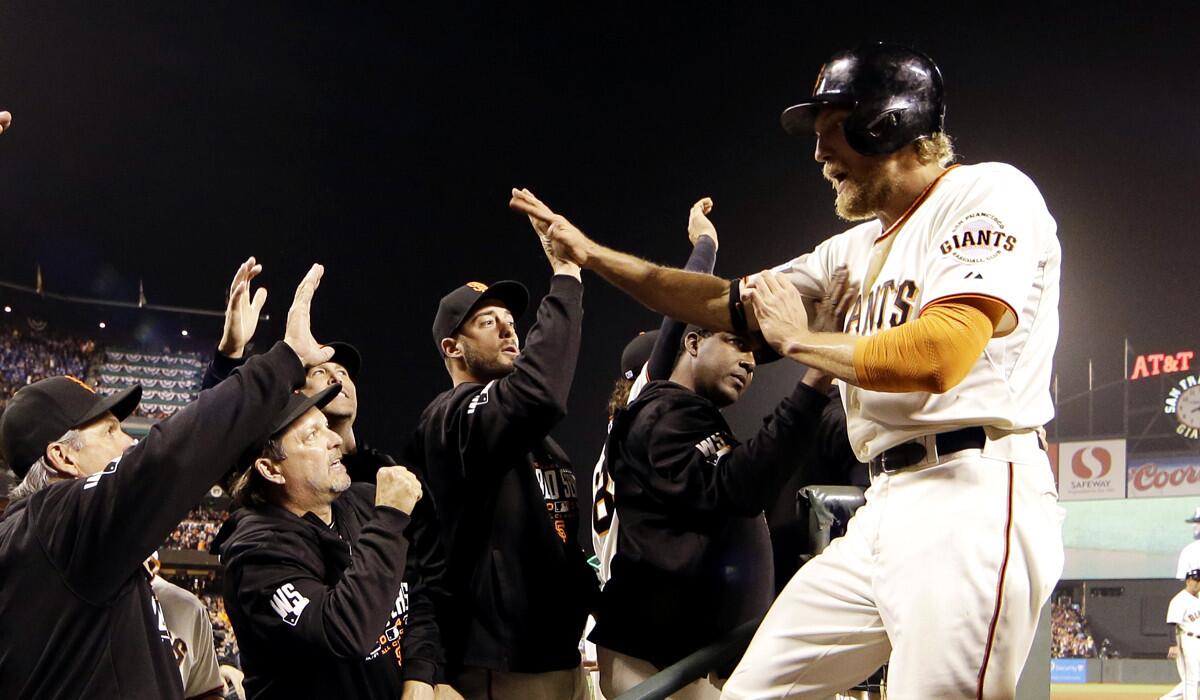Giants right fielder Hunter Pence is congratulated in the dugout after scoring against the Giants in the three-run sixth inning of Game 4 on Saturday night in San Francisco.