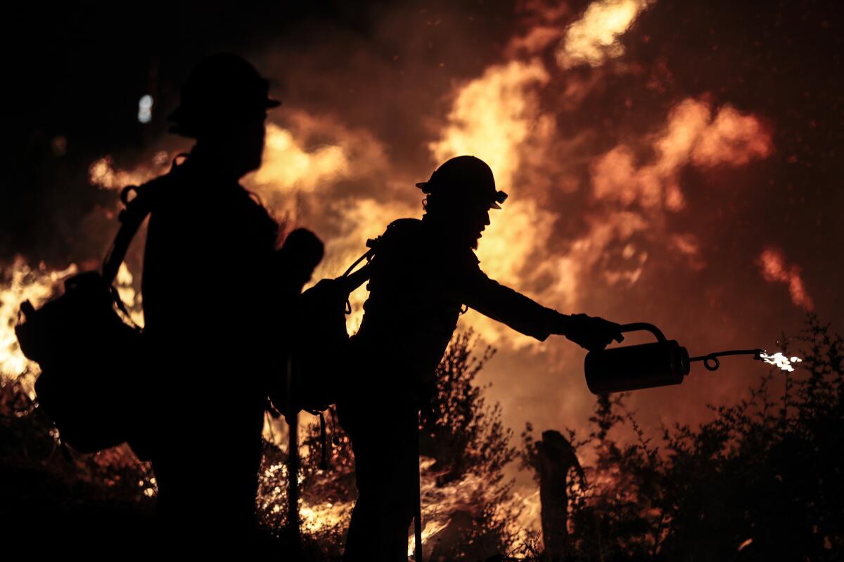 Firefighter silhouetted against flames