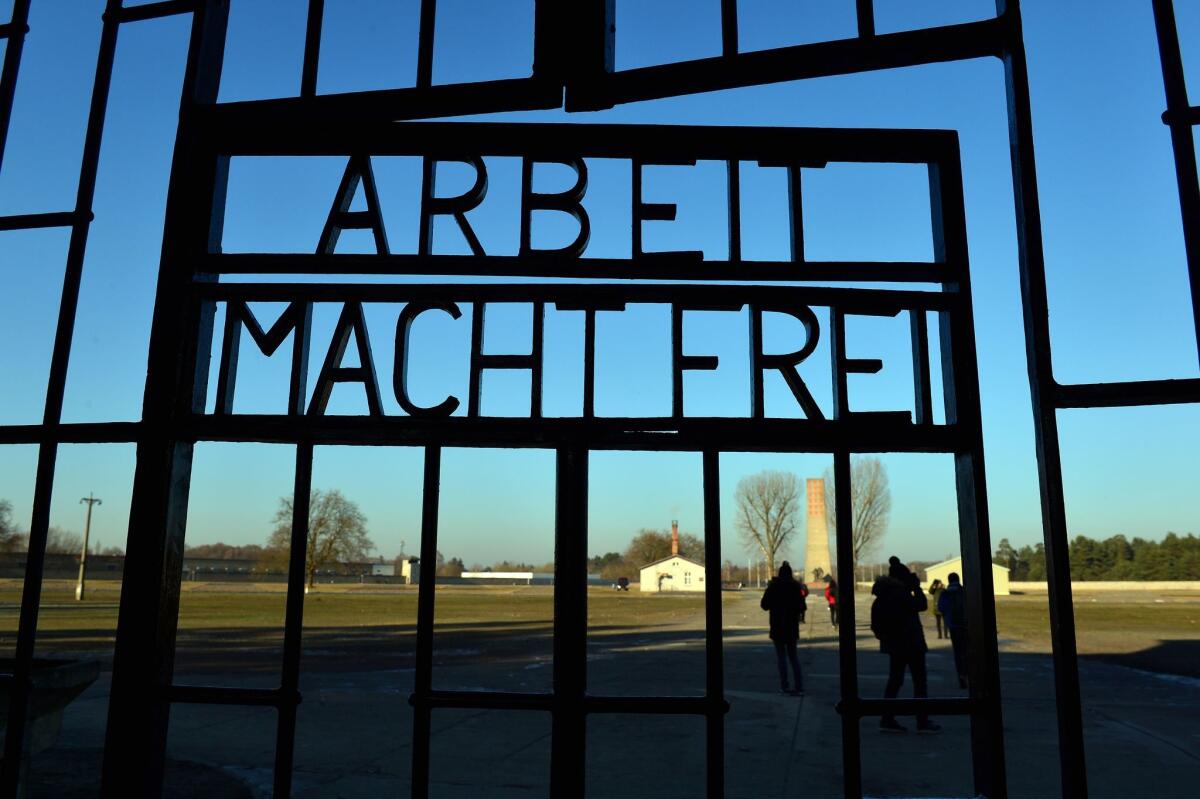 Visitors are seen behind a gate with the inscription "Arbeit macht frei" (Work Will Set You Free) on the grounds of the Sachsenhausen memorial of a former Nazi concentration camp in Oranienburg near Berlin on Friday.