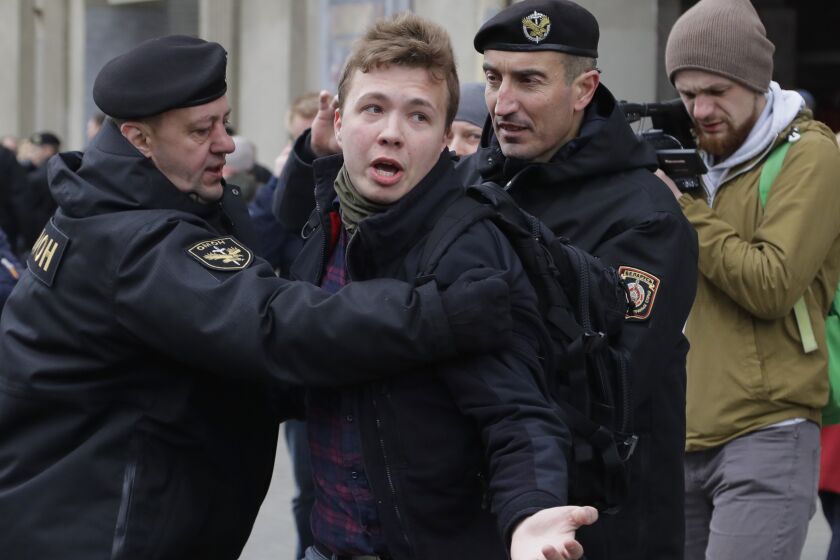 FILE - Belarus police arrest journalist Raman Pratasevich, center, in Minsk, Belarus, Sunday, March 26, 2017. A Belarusian court has convicted a dissident journalist who was arrested after being pulled off a commercial flight that was diverted to the country. The court sentenced Raman Pratasevich to eight years in prison on Wednesday. (AP Photo, File)