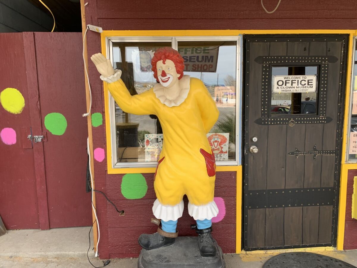 A Ronald McDonald clown stands at the entrance of the Clown Motel.