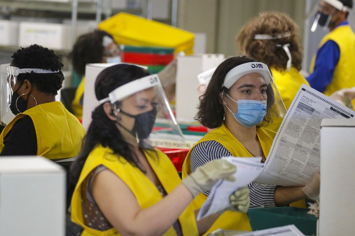 Nerissa Buelna, left, and Vivian Morales check ballots before sending them for counting in San Bernardino County