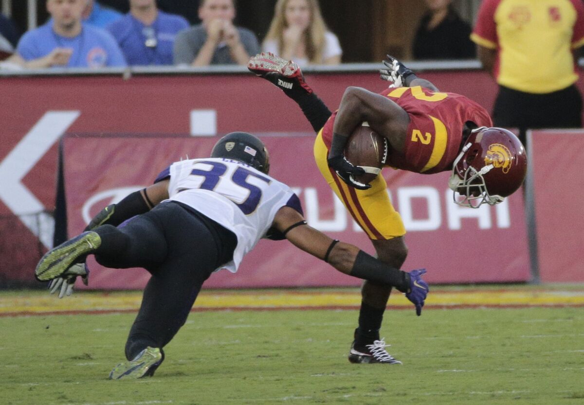 USC's Adoree' Jackson, right, avoids a tackle from Washington's Brian Clay during the first half on Thursday.