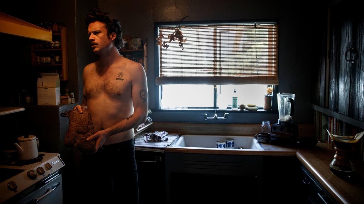 Singer Joshua Tillman, known by his stage name Father John Misty, prepares coffee inside his Los Angeles home. He's nominated for two Grammy Awards.