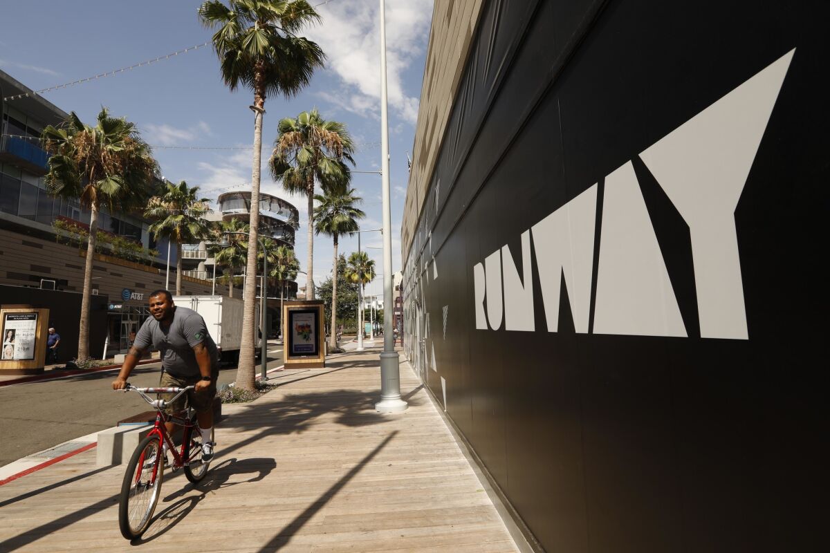 A bicyclist rides last month in the Runway shopping district in Playa Vista. Property manager DJM Capital Partners has decided to permanently close the middle section of Runway to auto traffic.