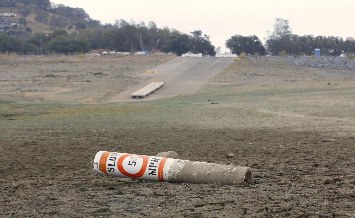 A warning buoy sits on the dry lake bed more than 100 yards away from a boat ramp at Folsom Lake in Folsom, Calif., last October.