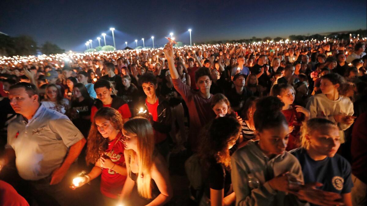 People hold candles during a vigil for the victims of the Wednesday shooting at Marjory Stoneman Douglas High School in Parkland, Fla. on Feb. 15, 2018.