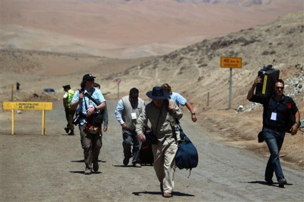 Journalists walk towards the San Jose Mine after it was closed to traffic, near Copiapo, Chile, Tuesday, Oct. 12, 2010. Andres Sougarett, the Chilean engineer leading the rescue effort, said all would be in place at midnight Tuesday to begin the rescue of the 33 trapped miners. (AP Photo/Natacha Pisarenko)