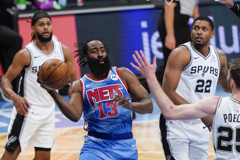 Brooklyn Nets' James Harden (13) looks to pass away from San Antonio Spurs' Rudy Gay (22) during the second half of an NBA basketball game Wednesday, May 12, 2021, in New York. (AP Photo/Frank Franklin II)