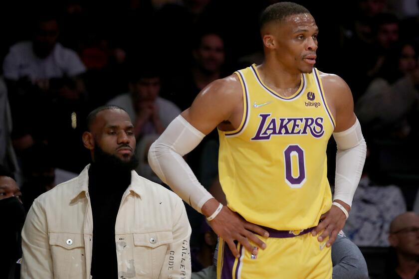 LOS ANGELES, CALIF. - NOV. 4, 2021. Laker star LeBron James watches from the bench as teammate Russell Westbrook plays against the thunder in the first quarter at Staples Center in Los Angeles on Thursday, Nov. 4, 2021. (Luis Sinco / Los Angeles Times)