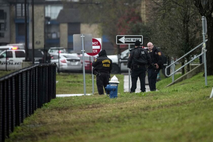 Police wait outside of Wisdom High School where police spent time searching the building after reports that a suspect ran into the building, Thursday afternoon, Feb. 2, 2023, in Houston. (Yi-Chin Lee/Houston Chronicle via AP)