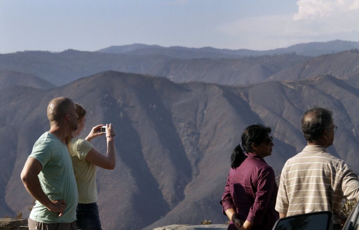 Tourists at the Rim of the World vista point near Yosemite look at the burn area Friday.