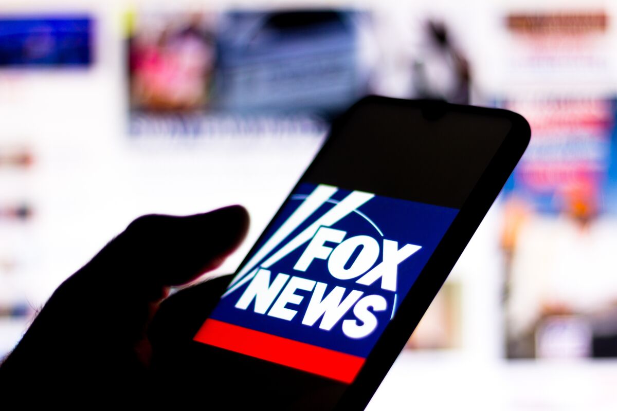Photo illustration with Fox News Channel logo seen displayed on a smartphone.