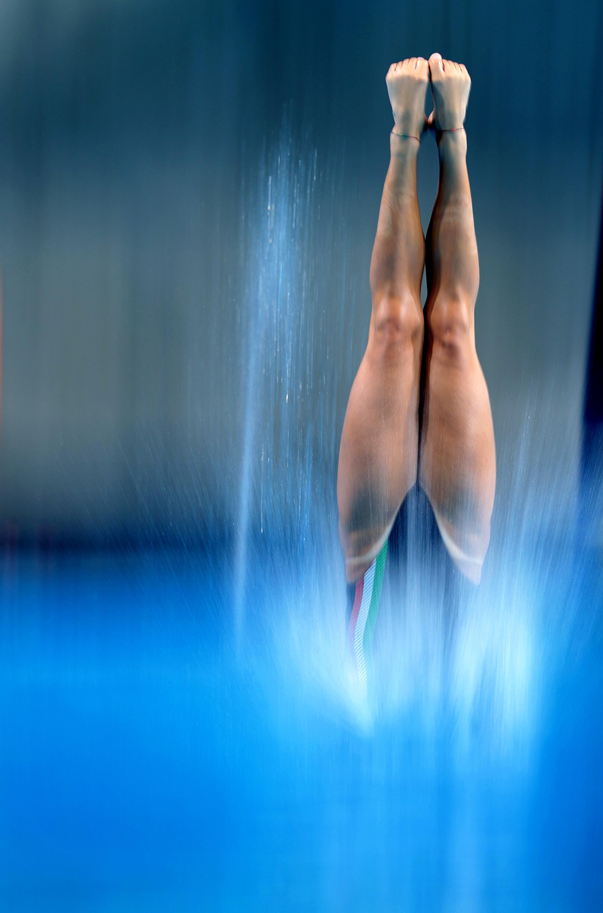 Divers warm-up in the women's 10 meter platform preliminaries at the 2024 Paris Olympics Monday. 