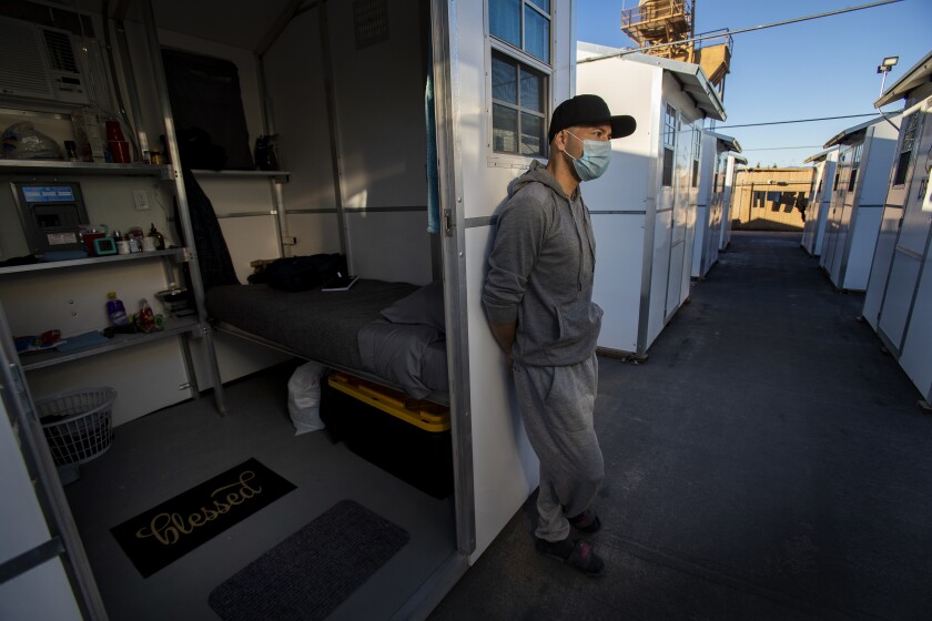 Carlos Beltran stands outside his home in the tiny home village.