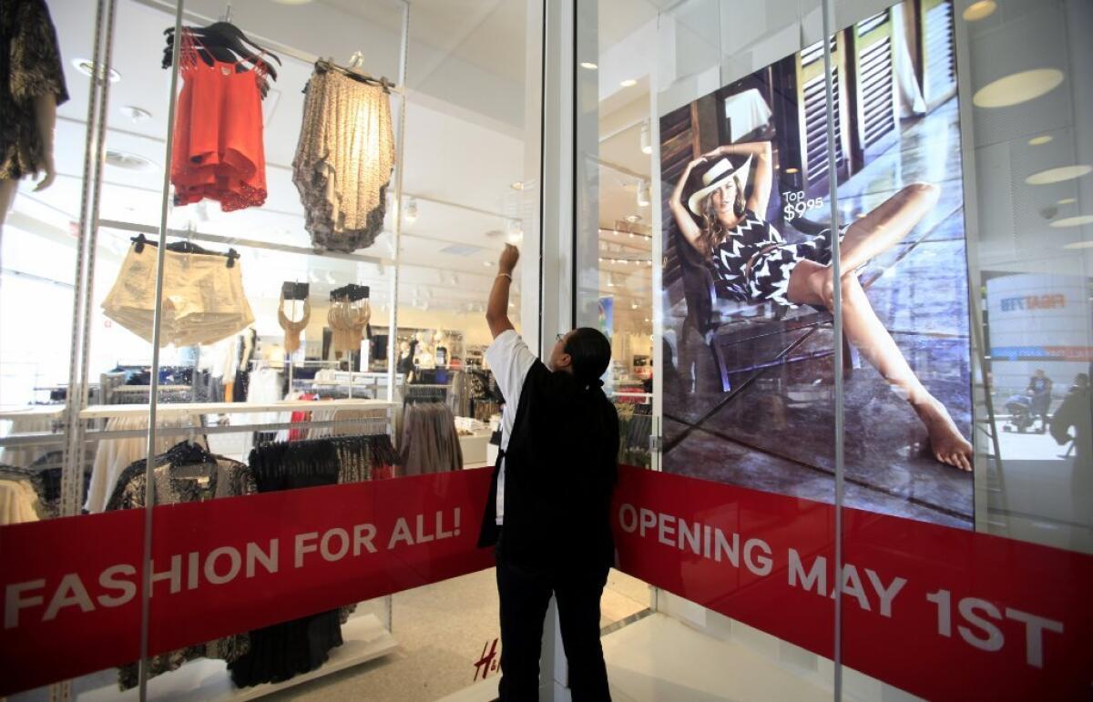 Hilda Cortes, 23, of Los Angeles cleans windows at the new H&M store opening in Los Angeles at the Figat7th complex.