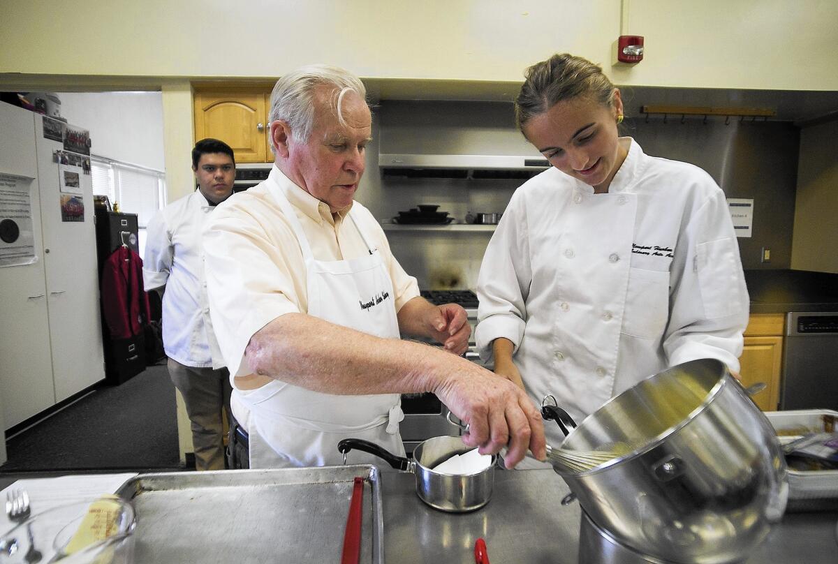 Wolf Burg, the president of the Anitbes Jumelage, prepares to cook a raspberry and fresh cream cake with Amanda Lacher, 17, during a cooking class at Newport Harbor High on Wednesday. Newport Beach Sister City Association is celebrating 25 years of sisterhood with Antibes, France.