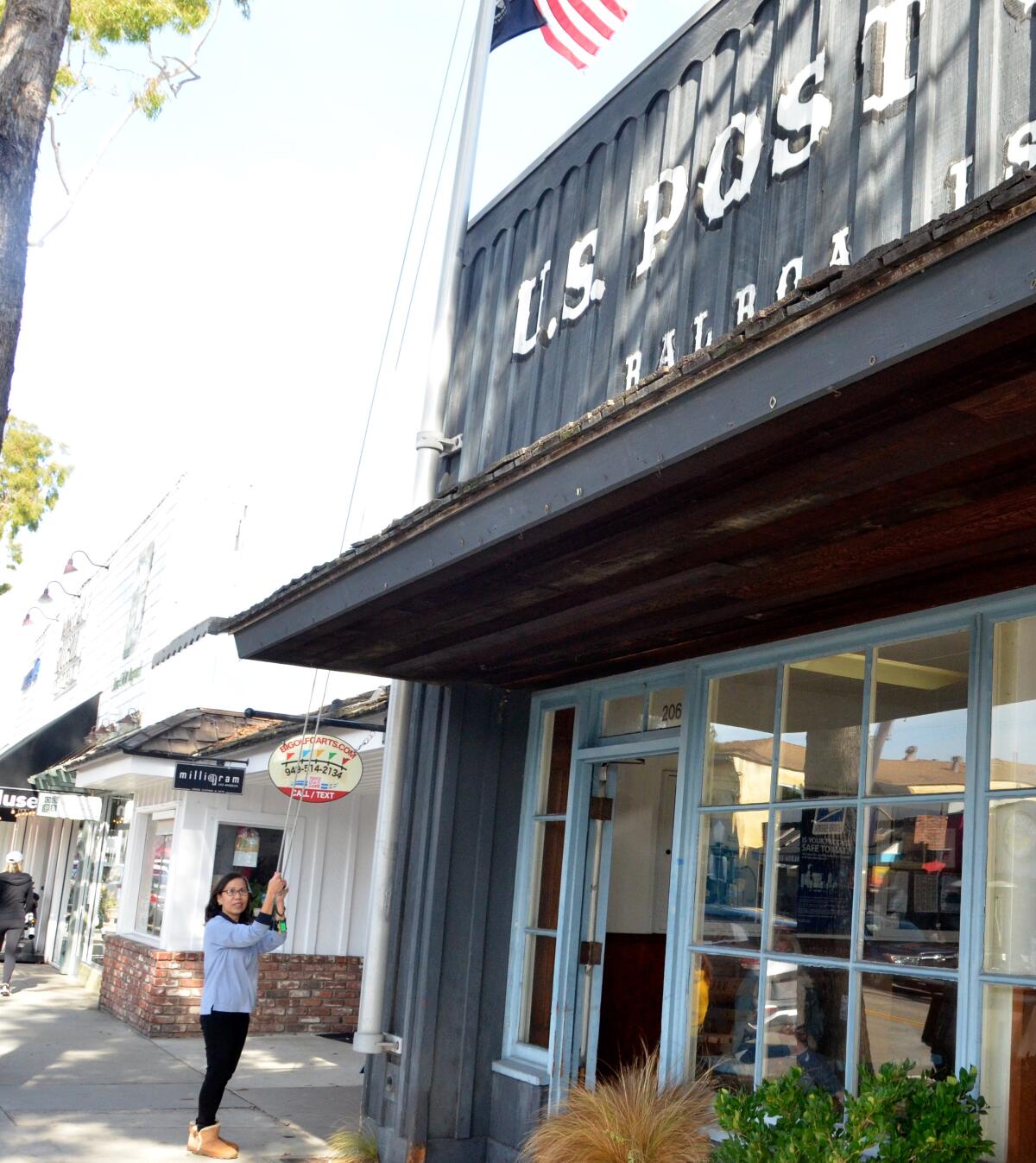 Tiffany Nguyen raises the U.S. flag every day as the Balboa Island post office clerk.