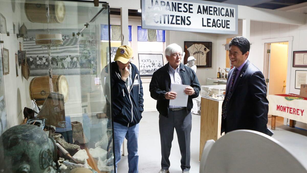 Japanese American Citizens League board members Tim Thomas, left, and Larry Oda speak with Mitchell Maki, president and CEO of the Go for Broke National Education Center.