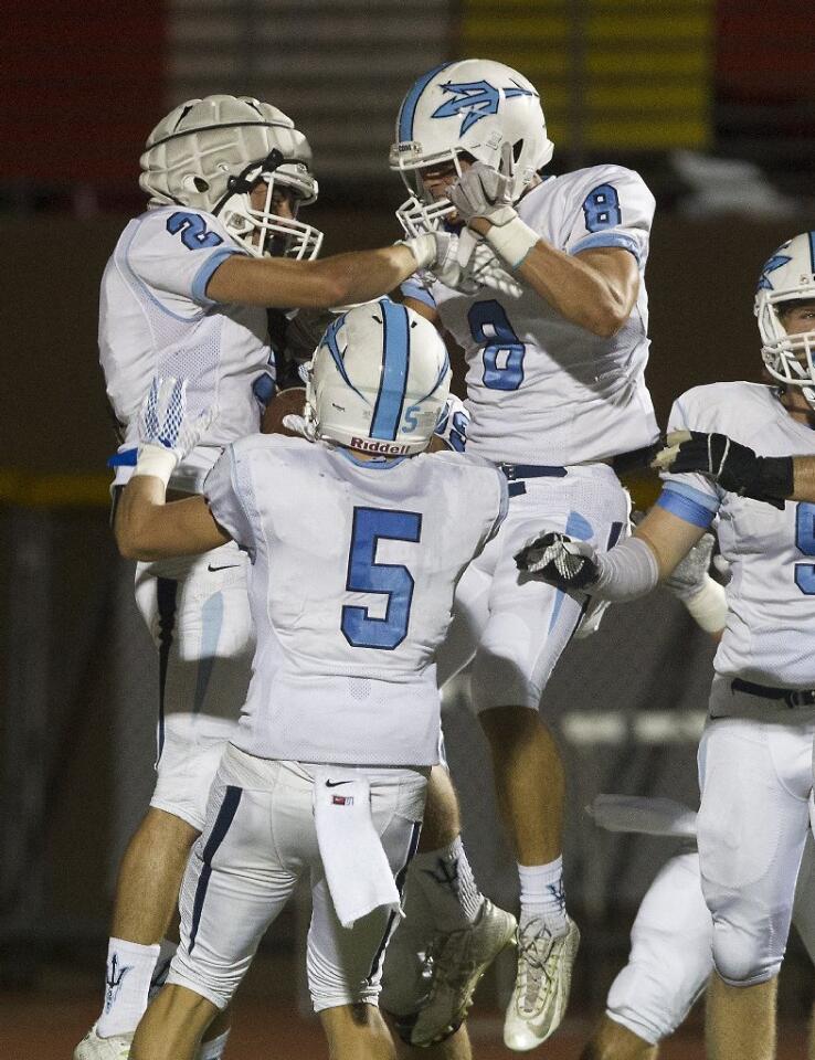 Corona del Mar High's Sutty Barbato (2) celebrates a touchdown with teammates Taylor Damron (8) and Cameron Kormos (5) against Woodbridge during the first half on Friday. Damron caused a Woodbridge fumble and Barbato recovered it for a touchdown.