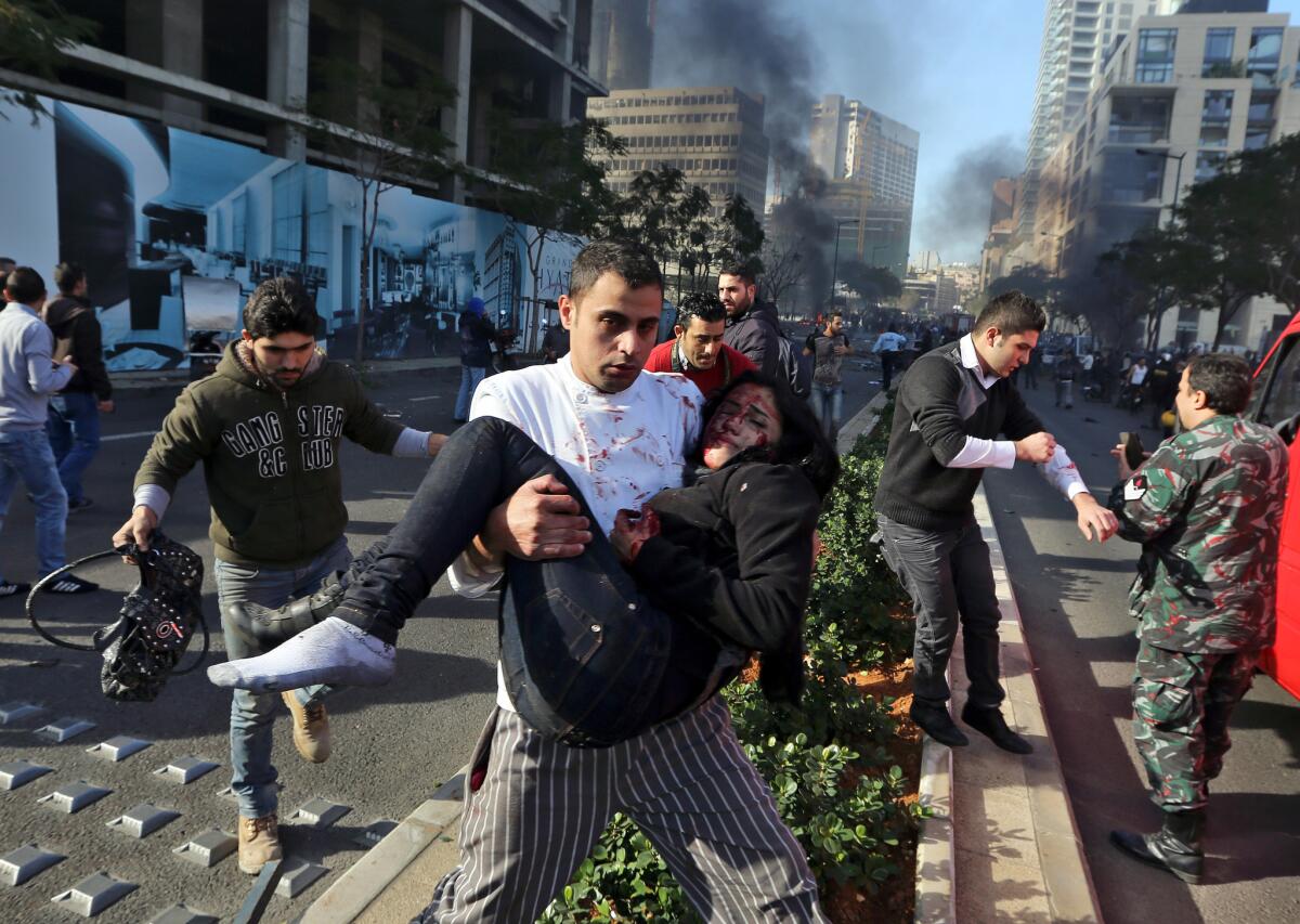 A man carries an injured woman at the scene of an explosion in central Beirut.