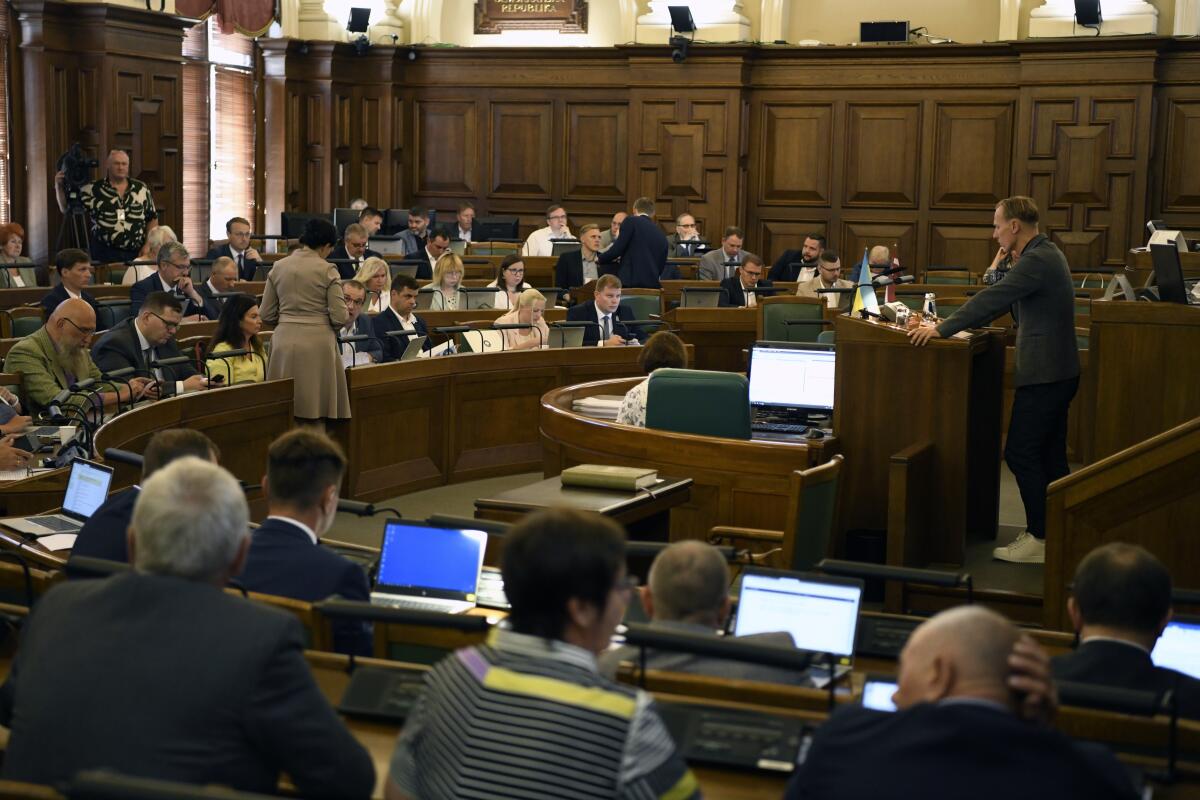In this handout photo released by the Parliament, Saeima, of the Republic of Latvia, Latvian lawmakers attend a session in Riga, Latvia, Thursday, Aug. 11, 2022. Latvia's Parliament has declared Russia a "state sponsor of terrorism" for attacks on civilians during the war in Ukraine and has urged other countries to follow suit. Lawmakers on Thursday adopted a strongly worded statement that accuses Moscow of using "suffering and intimidation as tools in its attempts to demoralize the Ukrainian people and armed forces and paralyze the functioning of the state.'' (The Parliament, Saeima, of the Republic of Latvia via AP)