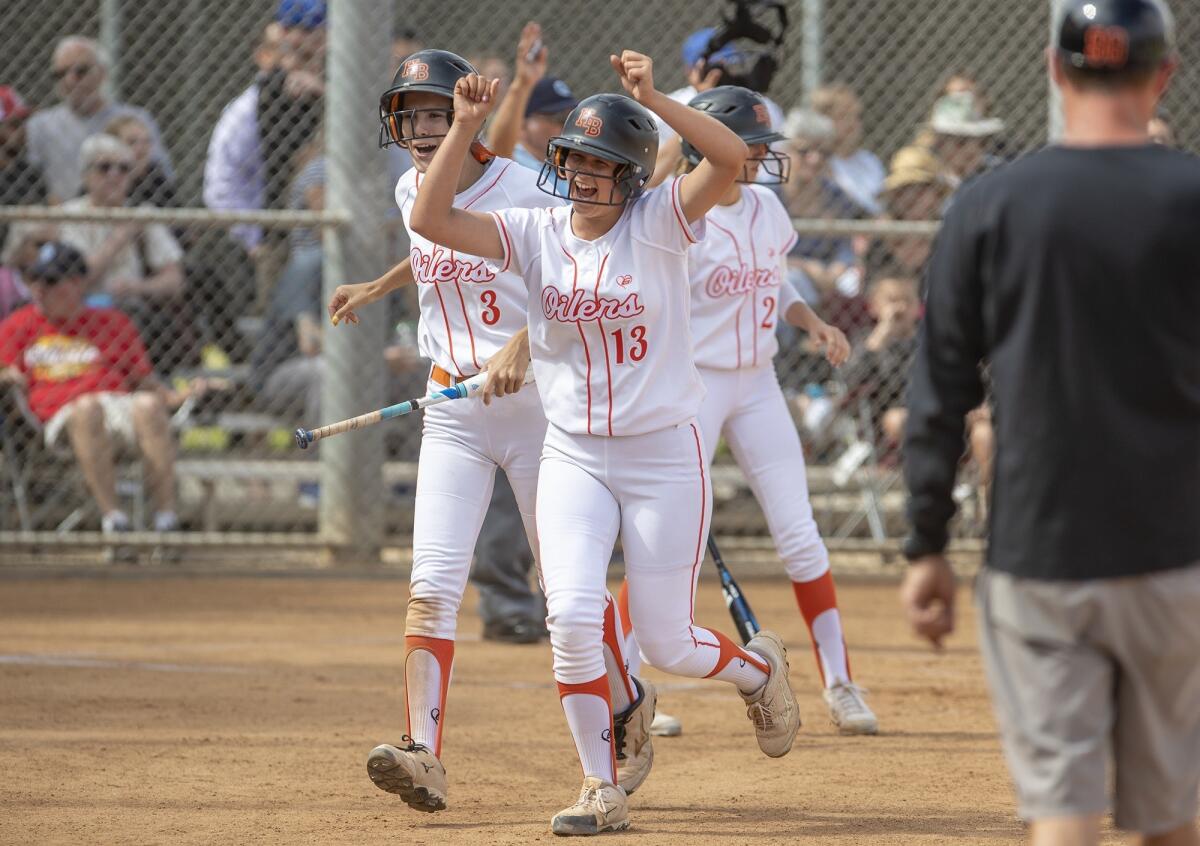 Huntington Beach High's Katelyn Mangrello, left, and Ameryn Humble celebrate scoring on an error in the second inning of the CIF Southern Section Division 1 semifinal playoff game against Norco on Tuesday.