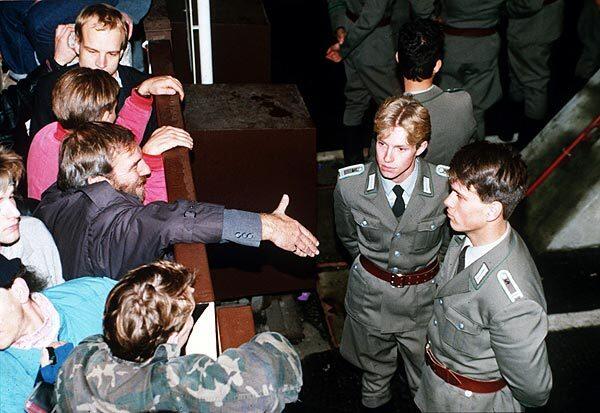 East German border police refuse to shake hands with a Berliner at a border fence near Checkpoint Charlie on Nov. 10, 1989, the day after the wall was opened.