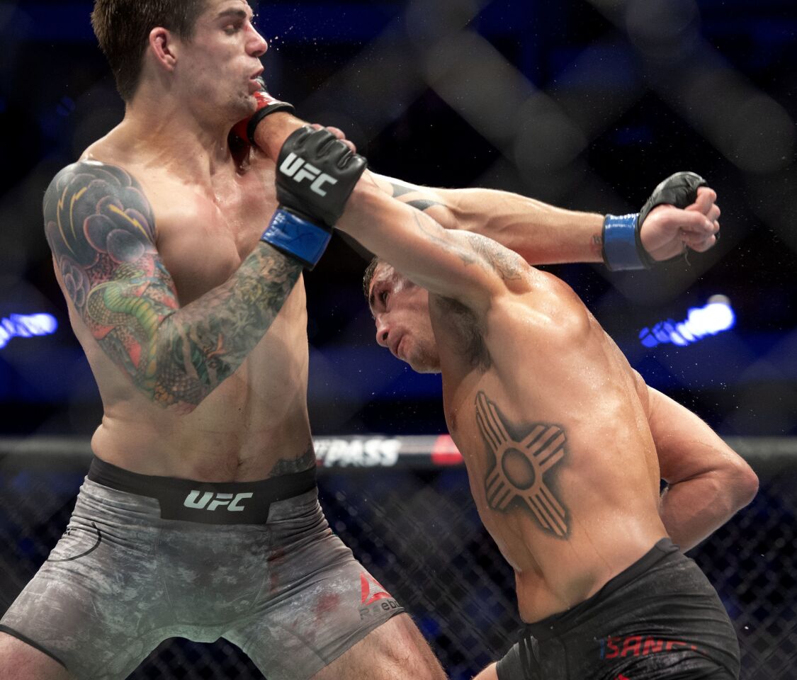 Diego Sanchez, right, punches Craig White during their welterweight mixed martial arts bout at UFC 228 on Saturday, Sept. 8, 2018, in Dallas. (AP Photo/Jeffrey McWhorter)