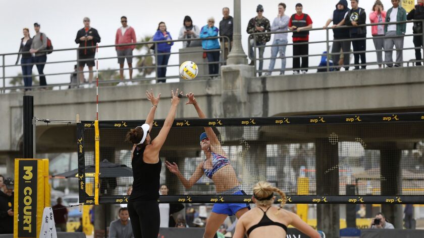 A crowd watches the Pro Beach Volleyball Open in 2017 from the Huntington Beach pier. But the support staff for the tourist trade in "Surf City USA" can't afford to live in town.